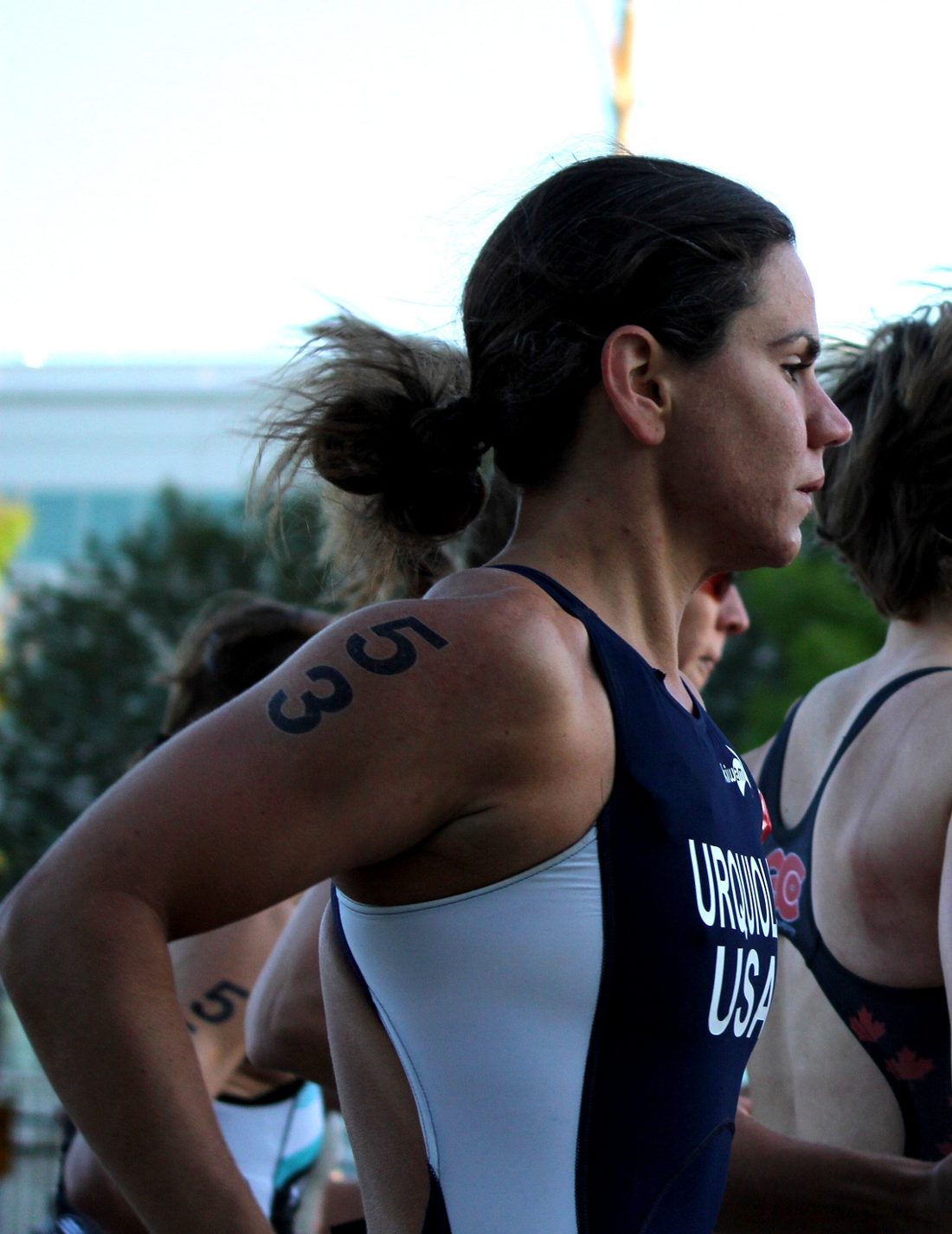 Erica Urquiola at a race start in her USA kit, looking ahead