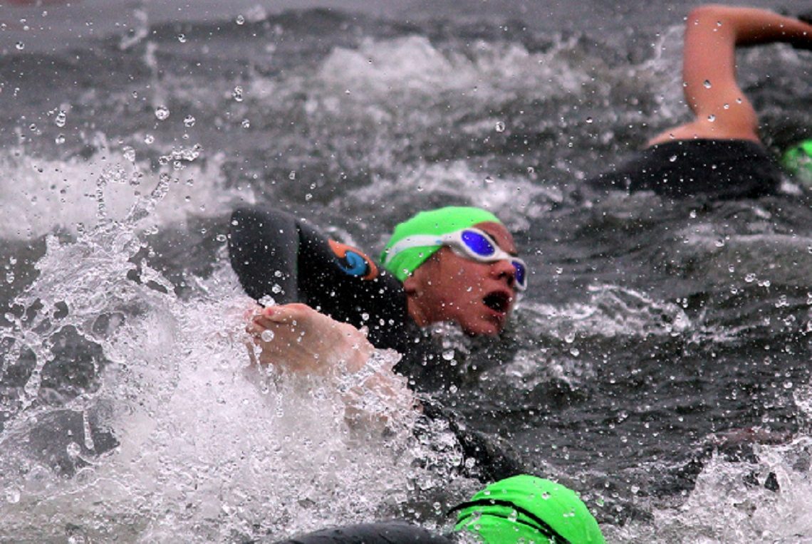 Erica swimming in open water in a green cap